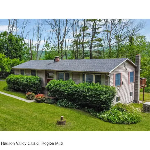 a view of a house with a yard and sitting area