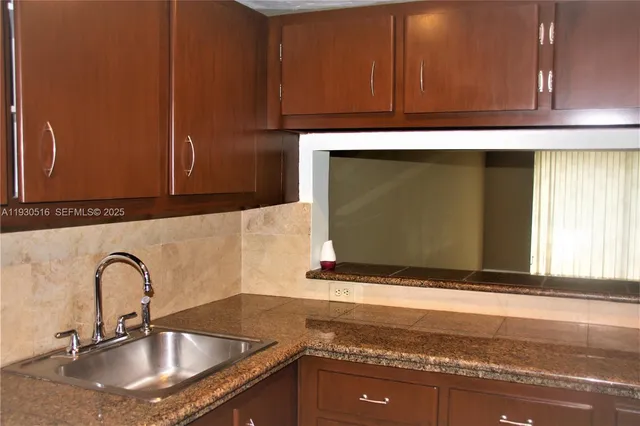 a kitchen with granite countertop a sink and a stove