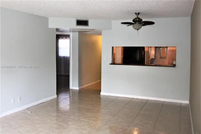 a view of a livingroom with a ceiling fan and hardwood floor