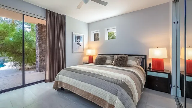 a bedroom with a bed and a lamp next to a window