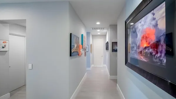 a view of a hallway with paintings on the wall