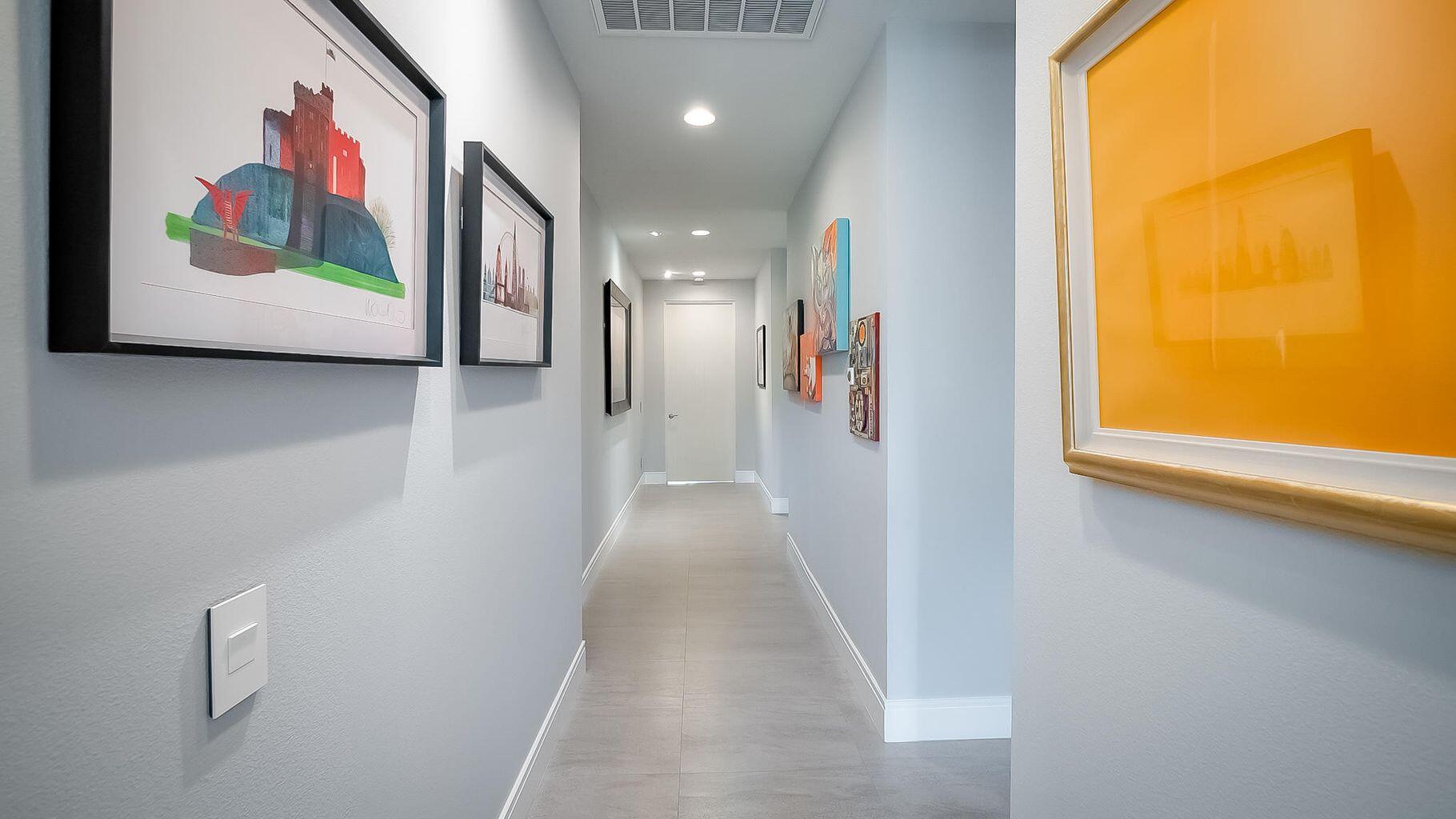2 Dominion Court Rancho Mirage, CA 92270 - Photo 20 of 40 a view of a hallway with paintings on the wall and a large window