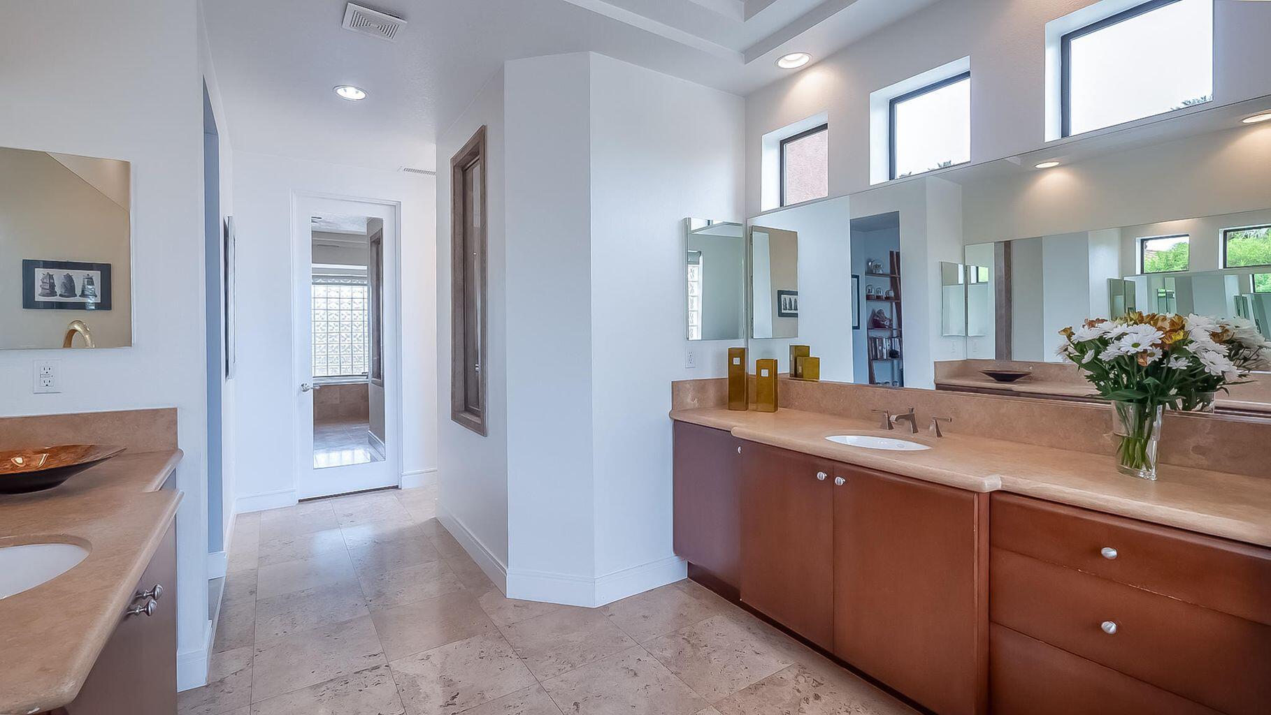2 Dominion Court Rancho Mirage, CA 92270 - Photo 23 of 40 a spacious bathroom with a granite countertop sink a mirror and shower