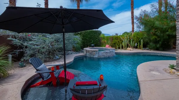 a view of a backyard with furniture and an umbrella