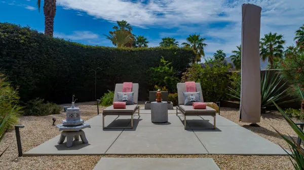 a view of a chairs and table in backyard