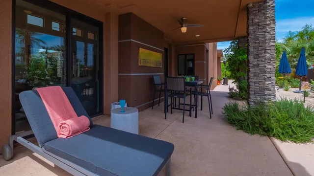 a view of a patio with table and chairs potted plants and floor to ceiling window
