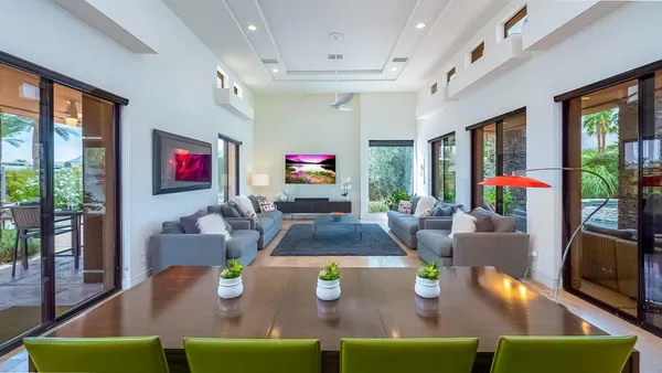 a living room with furniture a flat screen tv and a floor to ceiling window