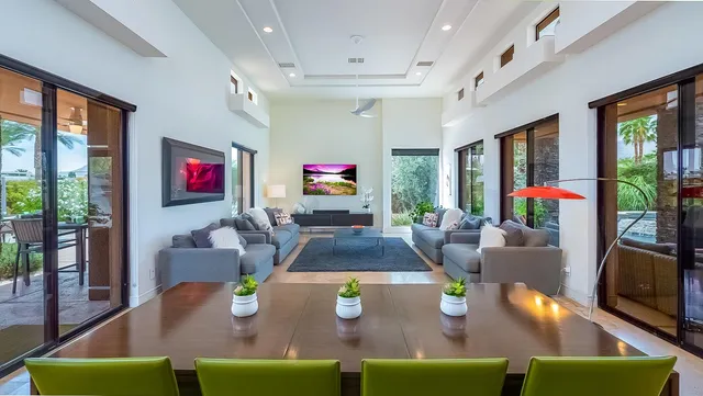 a living room with furniture a flat screen tv and a floor to ceiling window