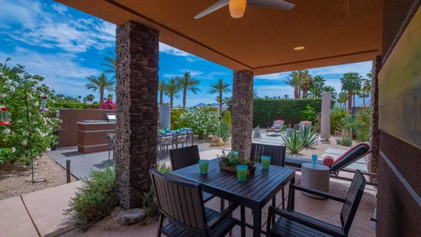 a view of an outdoor dining space with a table and chairs