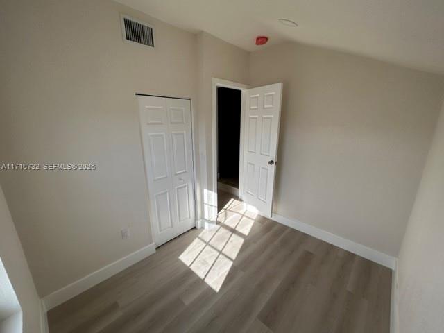 3529 Northwest 34th Street, Unit BACK Miami, FL 33142 - Photo 13 of 17 a view of an empty room with wooden floor and a window