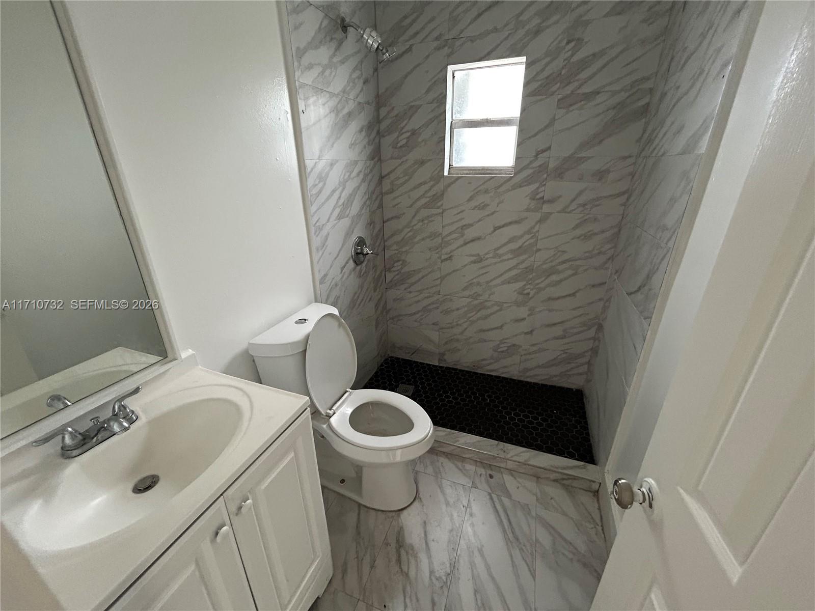3529 Northwest 34th Street, Unit BACK Miami, FL 33142 - Photo 16 of 17 a bathroom with a sink and a toilet