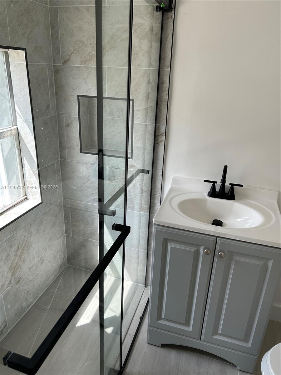 3529 Northwest 34th Street, Unit BACK Miami, FL 33142 - Photo 3 of 17 a bathroom with a sink and mirror