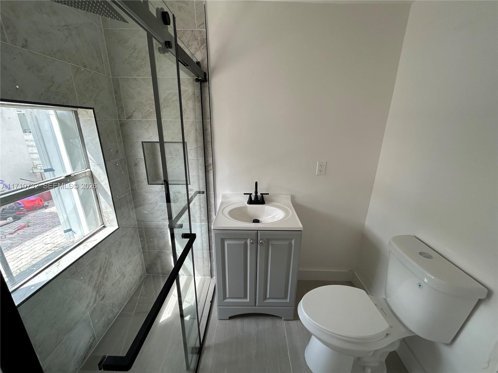 3529 Northwest 34th Street, Unit BACK Miami, FL 33142 - Photo 4 of 17 a bathroom with a toilet a sink and a mirror