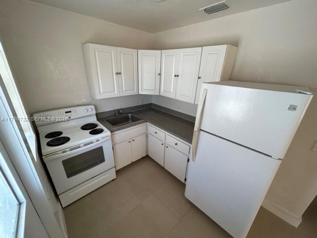 3529 Northwest 34th Street, Unit BACK Miami, FL 33142 - Photo 5 of 12 a kitchen with a stove a refrigerator and a sink