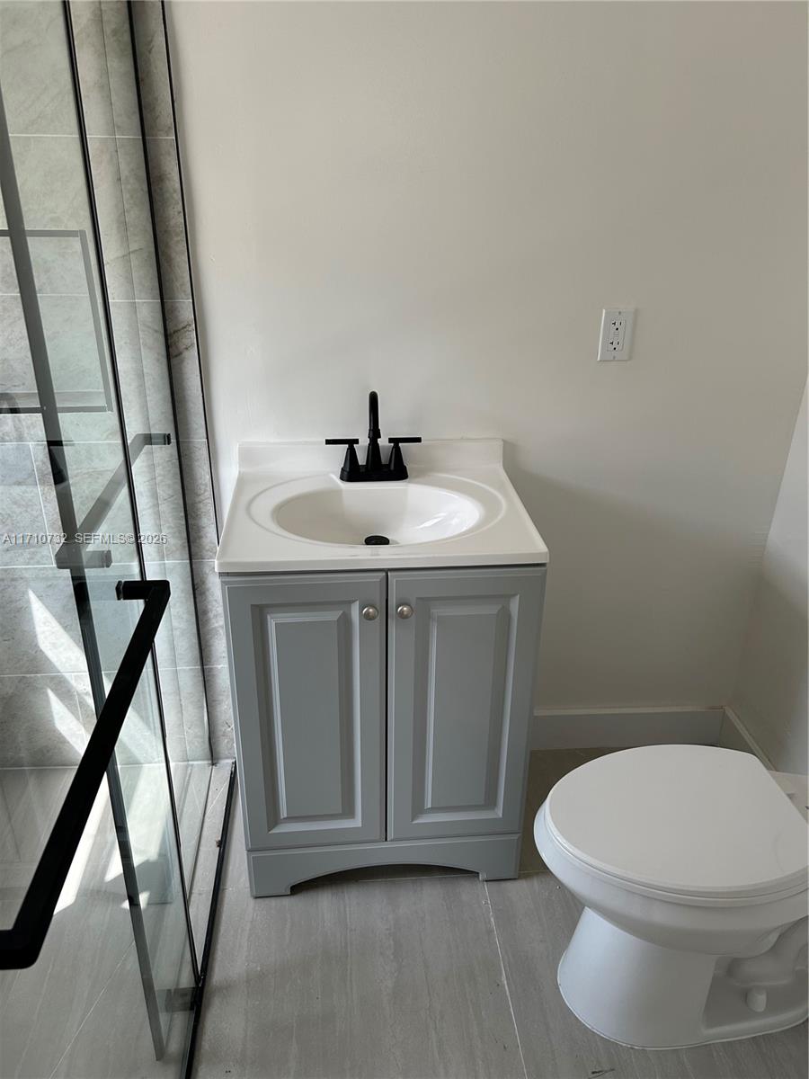 3529 Northwest 34th Street, Unit BACK Miami, FL 33142 - Photo 5 of 17 a bathroom with a sink a toilet and a mirror