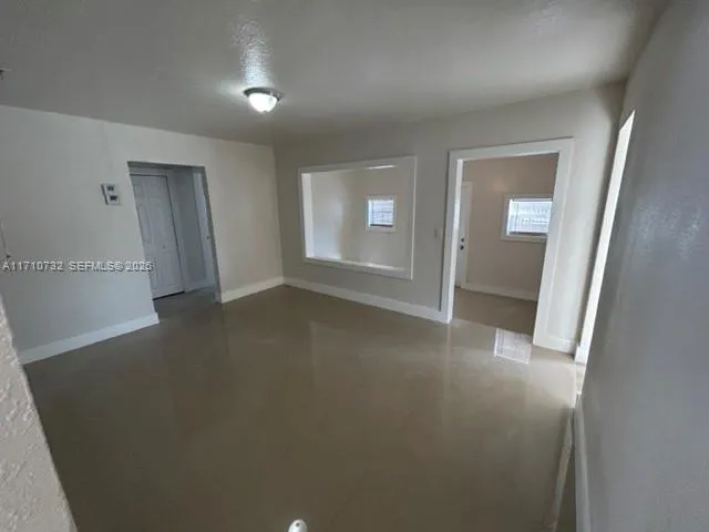 an empty room with windows and closet