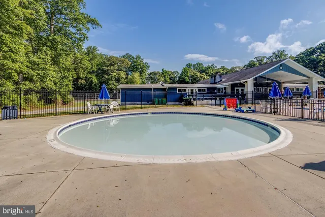a view of a swimming pool with a patio and a yard