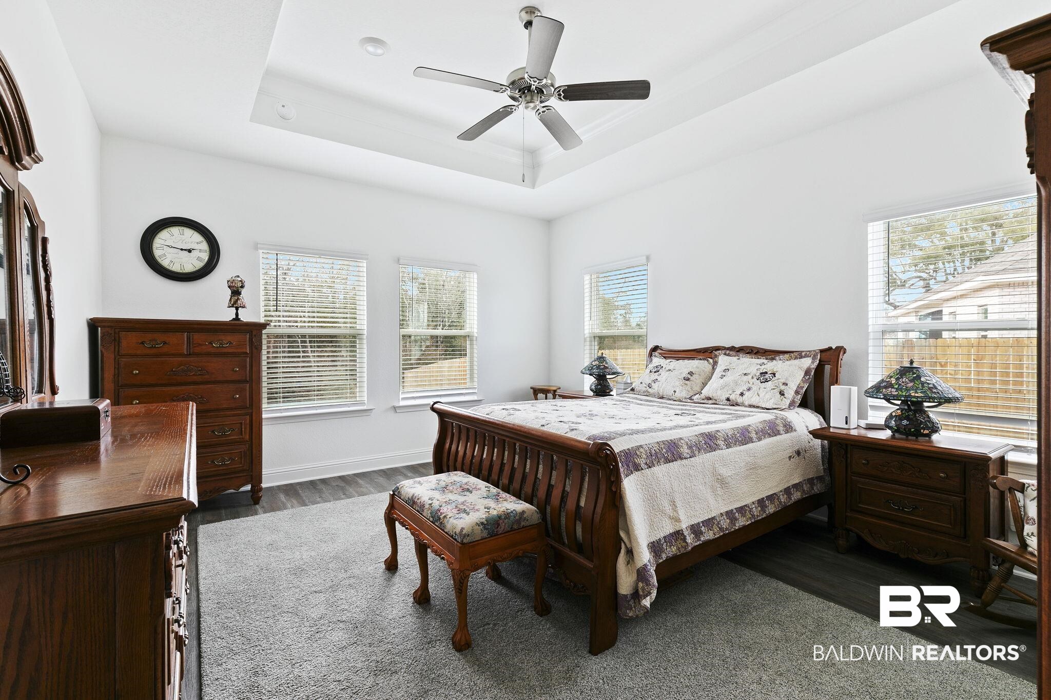 1141 Pencarro Boulevard Foley, AL 36535 - Photo 28 of 70 Bedroom with dark wood-type flooring, a raised ceiling, and ceiling fan