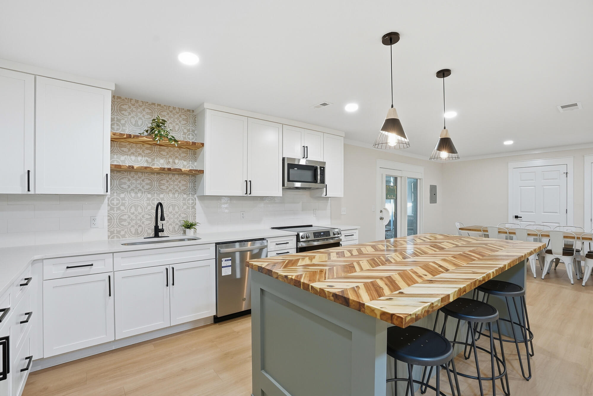 18 Initial Lane Santa Rosa Beach, FL 32459 - Photo 29 of 60 a kitchen with stainless steel appliances granite countertop a sink a stove a kitchen island with chairs and white cabinets