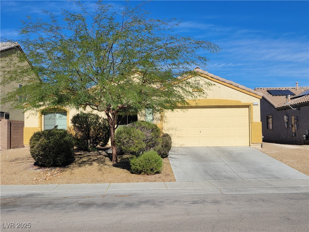 View of front of home featuring driveway, stucco siding, and an attached garage