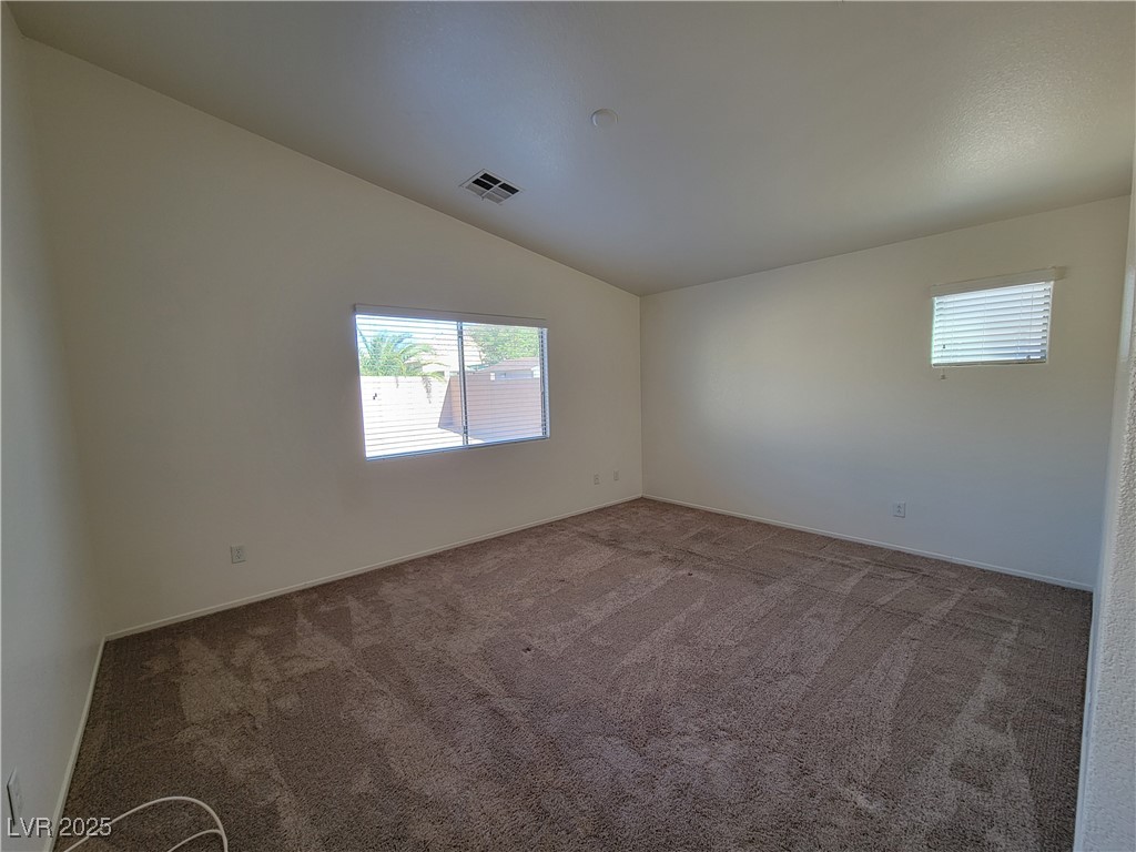 1112 Nevada Blaze Avenue North Las Vegas, NV 89081 - Photo 8 of 22 Empty room featuring carpet floors, plenty of natural light, and vaulted ceiling
