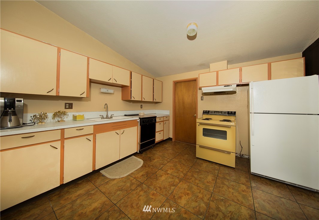 7461 Willow Grove Road Longview, WA 98632 - Photo 28 of 31 a kitchen with refrigerator a stove a sink and cabinets