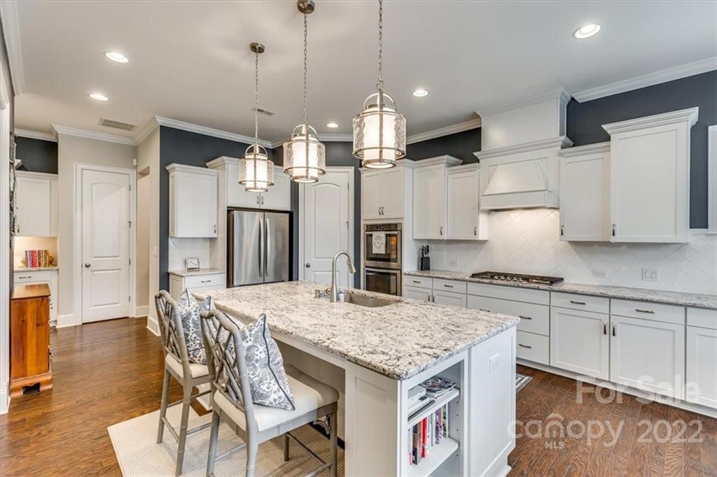 1489 Afton Way Fort Mill, SC 29708 - Photo 13 of 48 a kitchen with granite countertop a table chairs stove and refrigerator