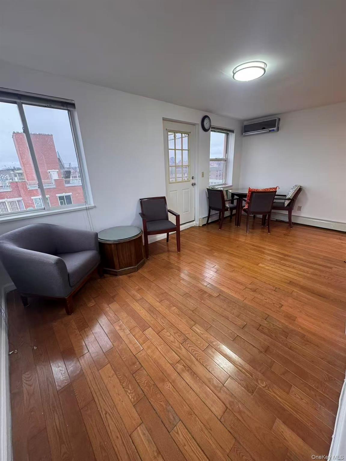 136-16 31st Road, Unit 8A Queens, NY 11354 - Photo 3 of 6 a living room with furniture and a wooden floor
