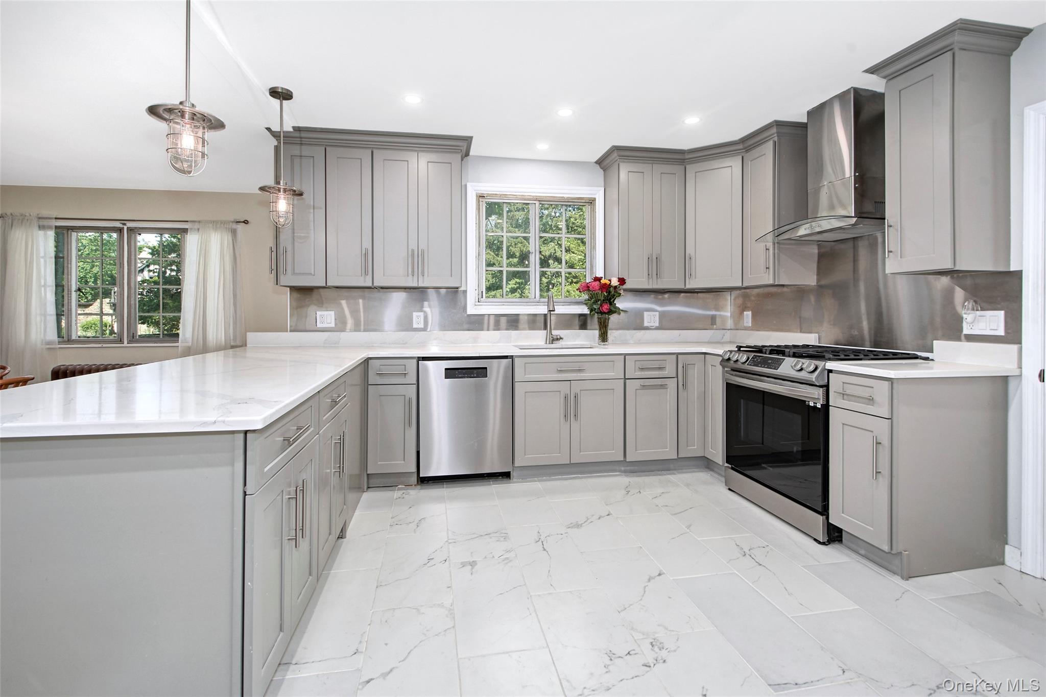 2 Byworth Road New Rochelle, NY 10804 - Photo 12 of 31 Kitchen featuring gray cabinetry, appliances with stainless steel finishes, wall chimney exhaust hood, and recessed lighting