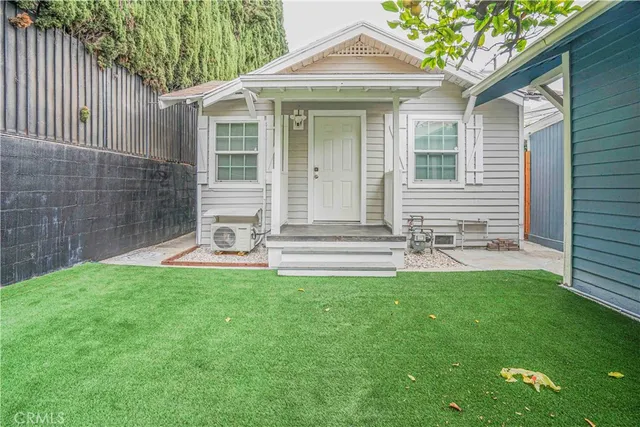 a front view of a house with a garden and yard