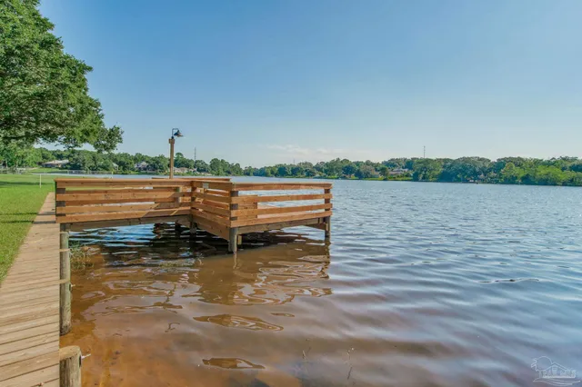 a view of a lake with outdoor space and trees in the back