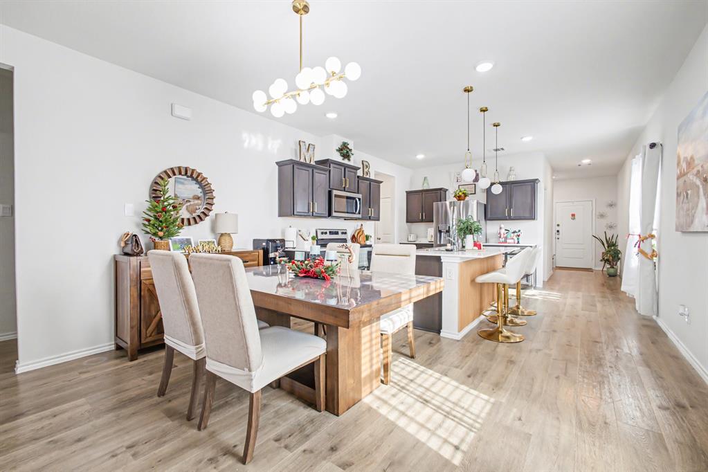 1301 Draper Lane Forney, TX 75126 - Photo 12 of 33 a living room with kitchen island furniture and a chandelier