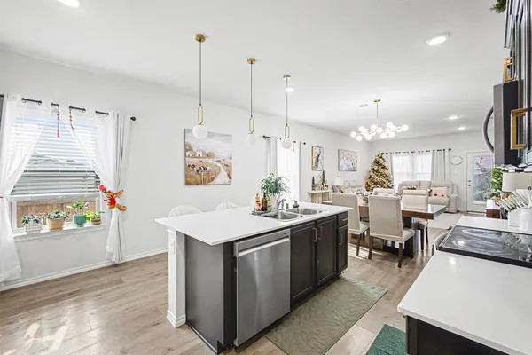 a kitchen with stainless steel appliances granite countertop a sink a stove and a wooden floors