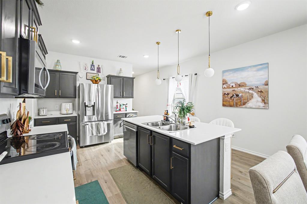 1301 Draper Lane Forney, TX 75126 - Photo 16 of 33 a kitchen with stainless steel appliances kitchen island granite countertop a sink stove and refrigerator