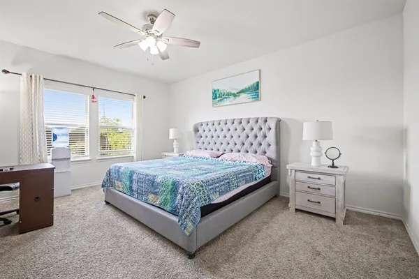 a bedroom with a bed and a chandelier fan