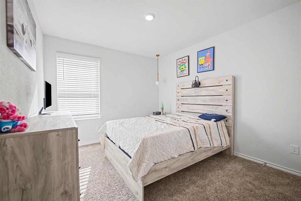 1301 Draper Lane Forney, TX 75126 - Photo 28 of 33 a bedroom with a bed and a chandelier