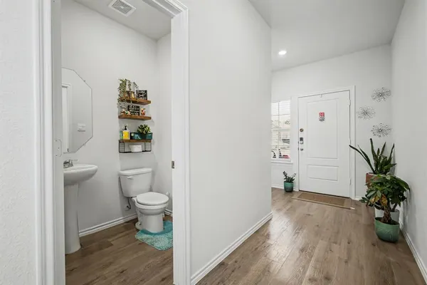 a bathroom with a toilet and a potted plant