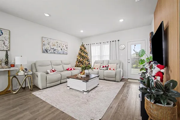 a living room with furniture potted plant and a flat screen tv