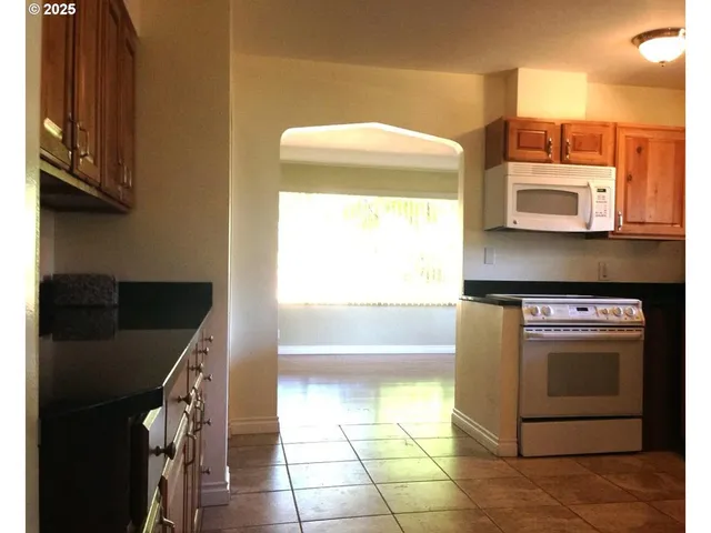 a kitchen with stainless steel appliances granite countertop a refrigerator and a stove