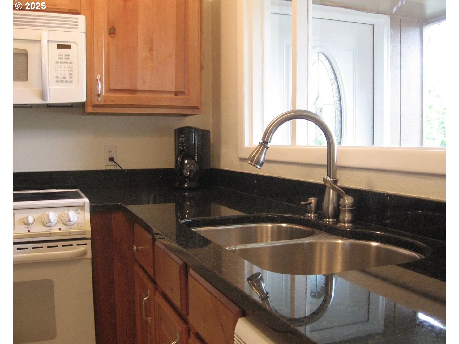 12025 Southwest 9th Street Beaverton, OR 97005 - Photo 9 of 22 a kitchen with granite countertop a sink a stove and cabinets