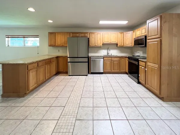 a kitchen with stainless steel appliances a refrigerator sink and cabinets