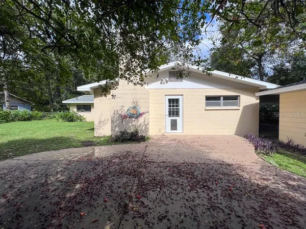 a view of a house with backyard and sitting area