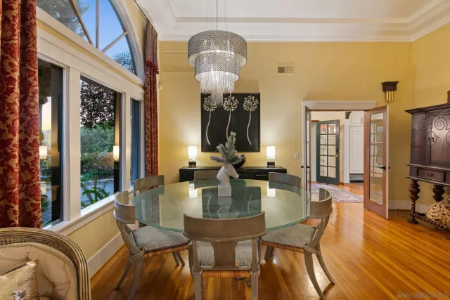 a view of a lake with lawn chairs and a large tree