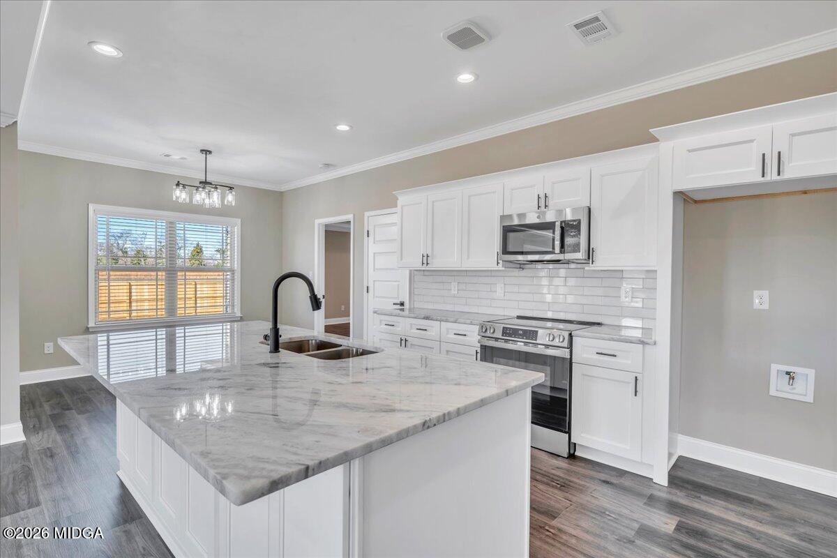 104 Early Drive Byron, GA 31008 - Photo 26 of 58 a kitchen with stainless steel appliances granite countertop a sink stove and cabinets
