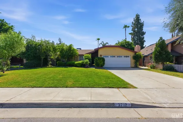 a front view of a house with a yard and a garage