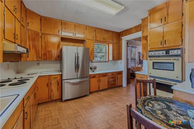 a kitchen with stainless steel appliances granite countertop a stove refrigerator sink and cabinets