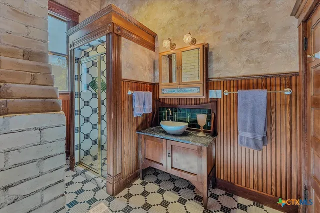 a bathroom with a granite countertop shower a mirror and a sink