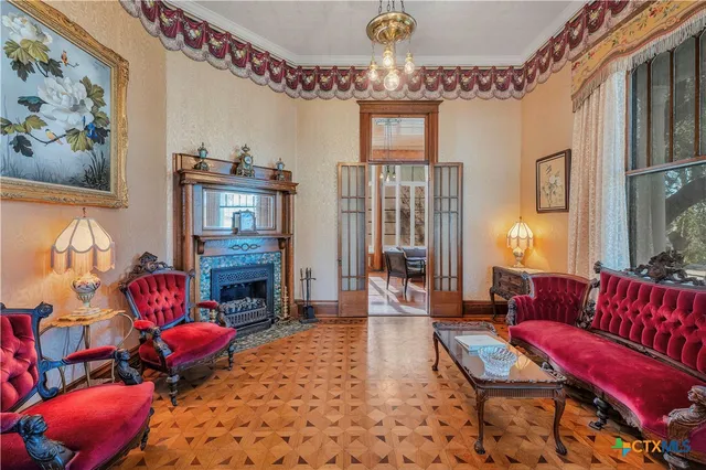 a living room with furniture a fireplace and a chandelier