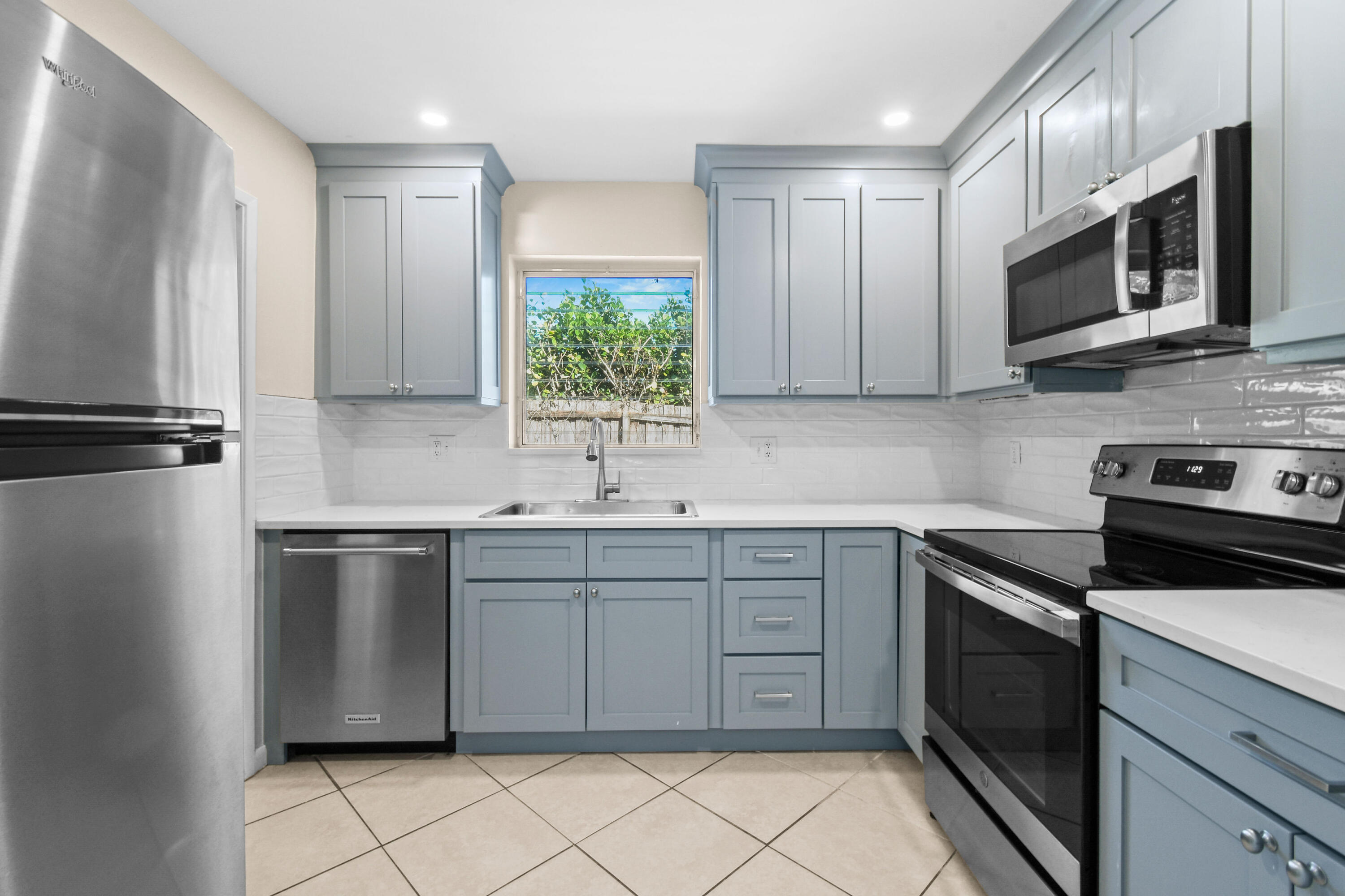 356 Cedar Avenue Tequesta, FL 33469 - Photo 15 of 51 a kitchen with stainless steel appliances granite countertop a sink and a stove top oven with white countertops