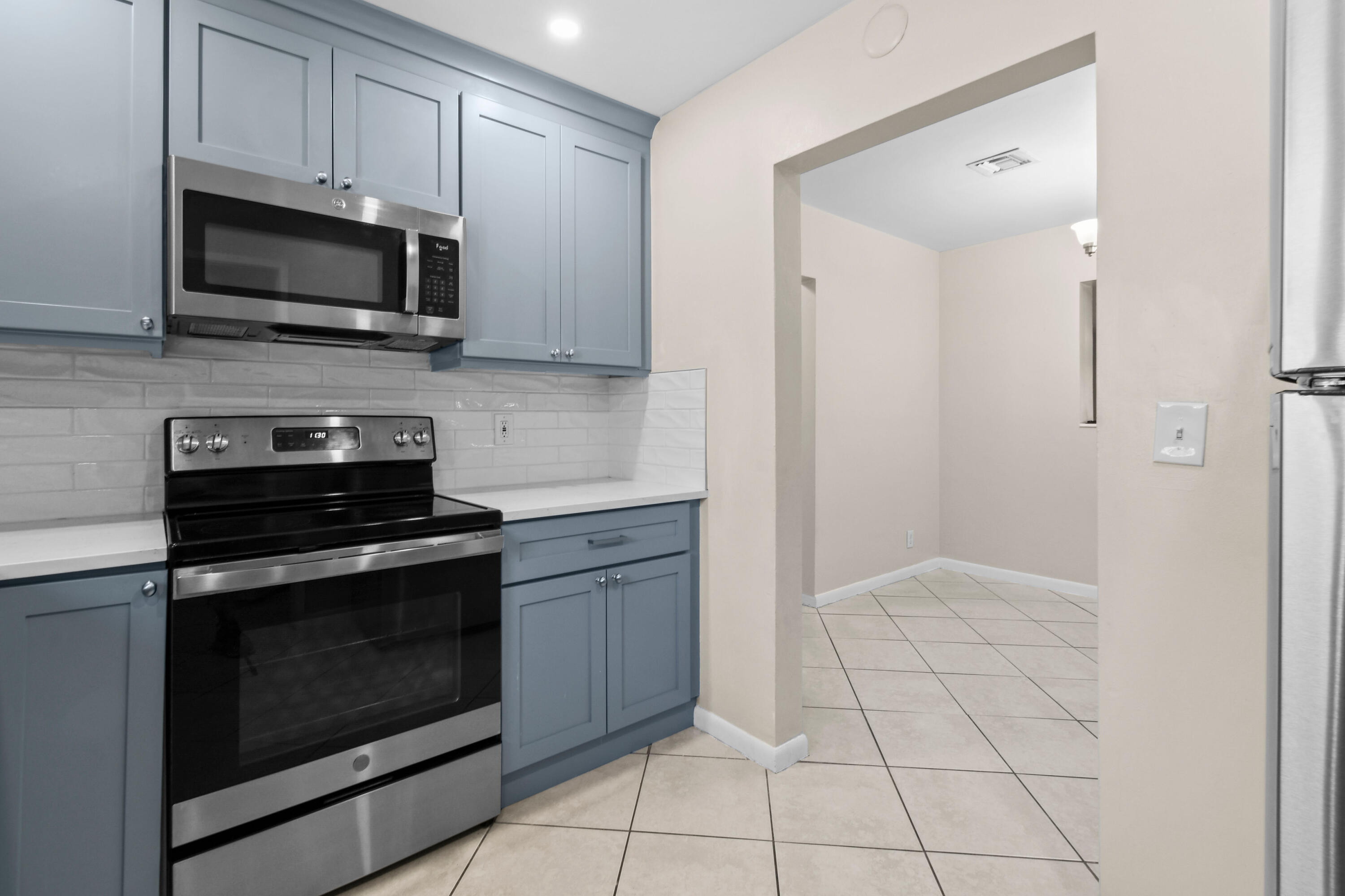 356 Cedar Avenue Tequesta, FL 33469 - Photo 19 of 51 a kitchen with granite countertop a stove a microwave and cabinets